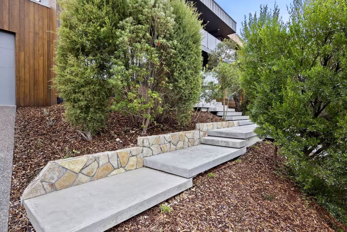 Floating concrete steps climbing a planted slope on the Mornington Peninsula