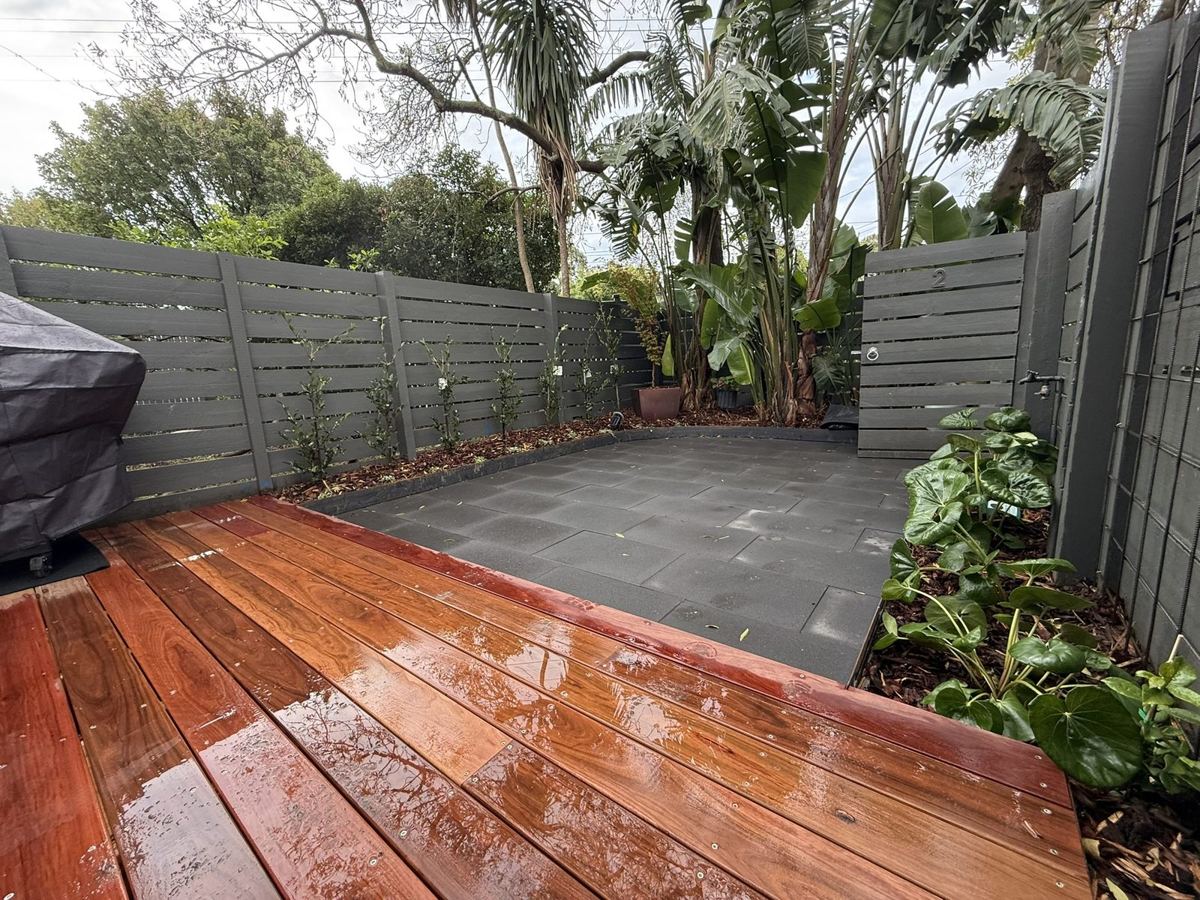 Ironbark deck, charcoal paving and layered planting in a Kew courtyard