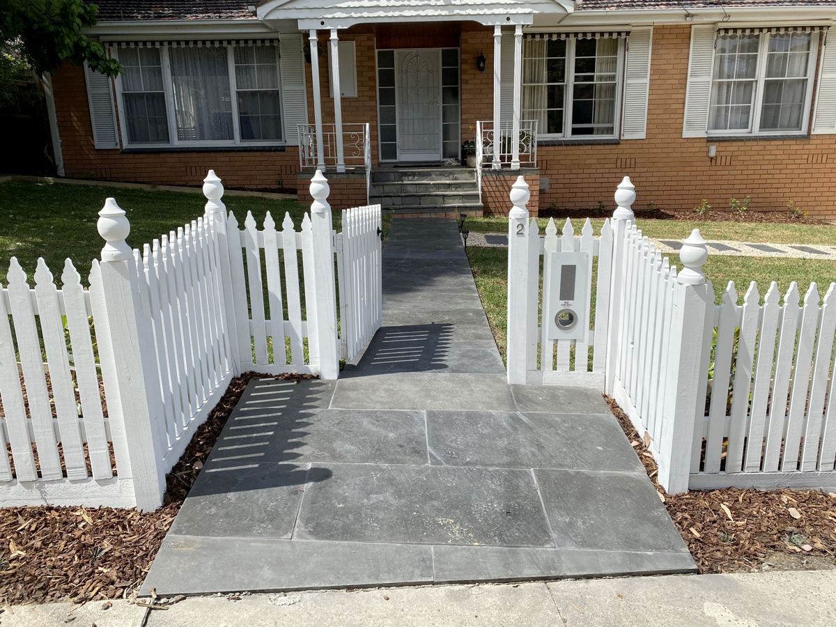Front garden with a timber picket fence and bluestone path in Blackburn